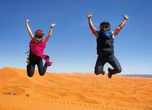 Happy clients in the desert dunes of Erg Chebbi in a Desert Tour From Fes